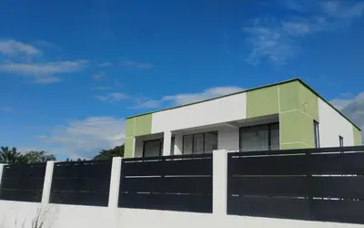 a white and green building behind a fence at Luxury Villa in Cerritos ride horses nearby in Pereira