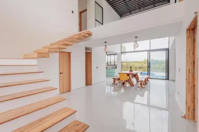 a dining room with stairs and a table at Luxury Villa in Cerritos ride horses nearby in Pereira