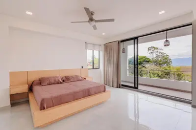 a bedroom with a bed and a large window at Luxury Villa in Cerritos ride horses nearby in Pereira