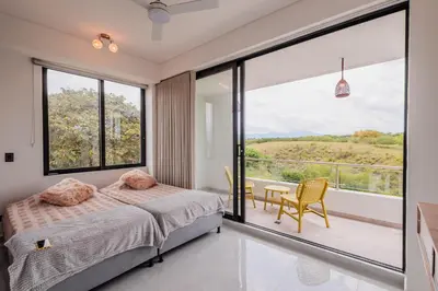 a bedroom with a bed and a large window at Luxury Villa in Cerritos ride horses nearby in Pereira