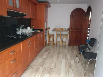 a kitchen with wooden cabinets and a table with chairs at Casa acogedora y excelente ubicación in Manizales