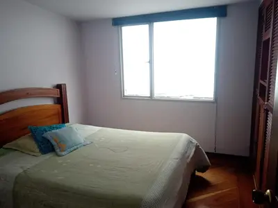 a bedroom with a bed with a large window at Casa acogedora y excelente ubicación in Manizales