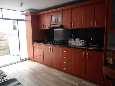a kitchen with wooden cabinets and a stove at Casa acogedora y excelente ubicación in Manizales