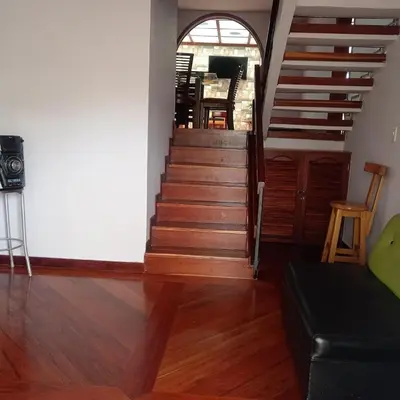 a staircase in a living room with a table and chairs at Casa acogedora y excelente ubicación in Manizales