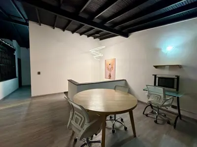 a room with a table and chairs and a fireplace at Exclusive house in the Malibu sector in Medellín