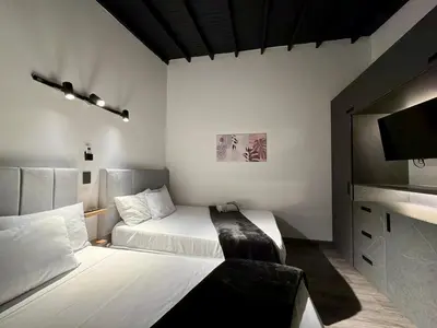 a hotel room with two beds and a flat screen tv at Exclusive house in the Malibu sector in Medellín