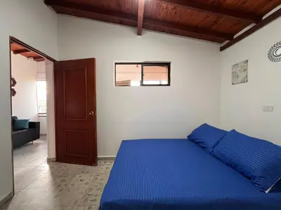 a bedroom with a blue bed and a door at Apartment near downtown in Medellín