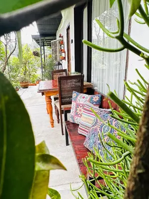 a wooden bench sitting on a porch with pillows at hotel campestre cerca del aeropuerto vía autopista Medellín Bogotá in Rionegro