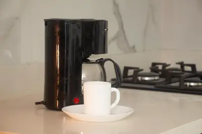 a coffee pot and a cup on a counter at Frente al mall Viva Envigado, AC, moderno in Envigado