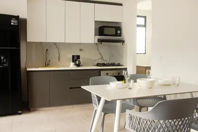 a kitchen with a table and chairs and a microwave at Frente al mall Viva Envigado, AC, moderno in Envigado
