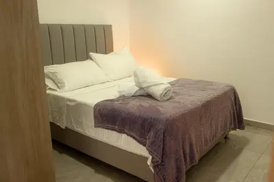 a bed with white pillows and a purple blanket at Frente al mall Viva Envigado, AC, moderno in Envigado