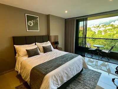 a bedroom with a large bed and a large window at Rooca Urban in Medellín