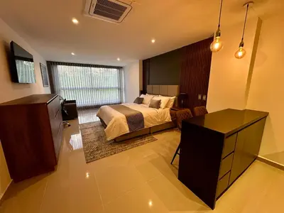 a bedroom with a bed and a television in a room at Rooca Urban in Medellín