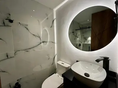 a white bathroom with a sink and a mirror at Rooca Urban in Medellín
