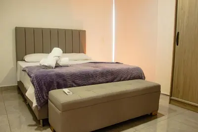 a bedroom with a bed with a purple blanket at Frente a Viva Envigado, AC, moderno e iluminado in Envigado