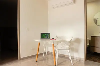 a table and two chairs with a laptop on it at Frente a Viva Envigado, AC, moderno e iluminado in Envigado