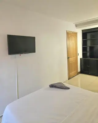 a white bed with a flat screen tv on the wall at master bedroom in Medellín