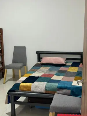 a bed with a colorful blanket and a chair at Finca Pacora in Palestina