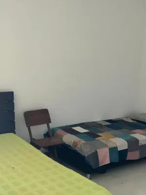 a room with two beds and a chair and a bed at Finca Pacora in Palestina