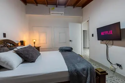 a bedroom with a bed with a tv on the wall at CASA GAMA Your spring in Medellín in Medellín