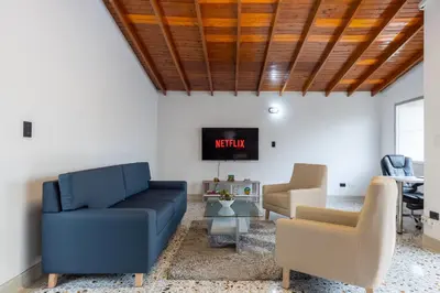 a living room with a couch and a tv at CASA GAMA Your spring in Medellín in Medellín