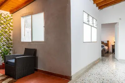 a living room with a chair and a wall at CASA GAMA Your spring in Medellín in Medellín
