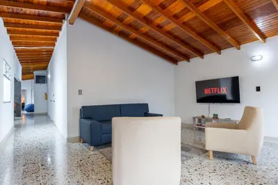 a living room with a blue couch and a tv at CASA GAMA Your spring in Medellín in Medellín