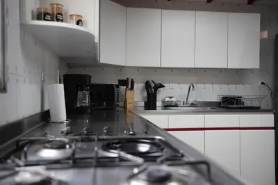 a kitchen with white cabinets and a stove top oven at CASA GAMA Your spring in Medellín in Medellín