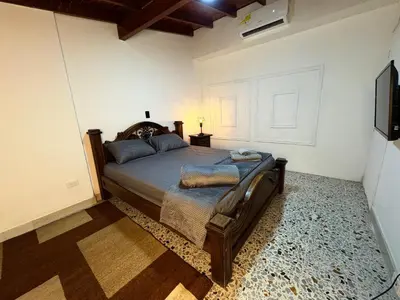 a bedroom with a bed and a flat screen tv at CASA GAMA Your spring in Medellín in Medellín