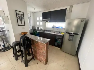 a kitchen with a stainless steel refrigerator and a counter at Apartasol santafe live in Santa Fe de Antioquia