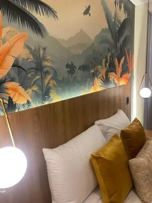 a bedroom with a large mural of palm trees at Hotel Ryo 74b Piso 7 Vip in Medellín