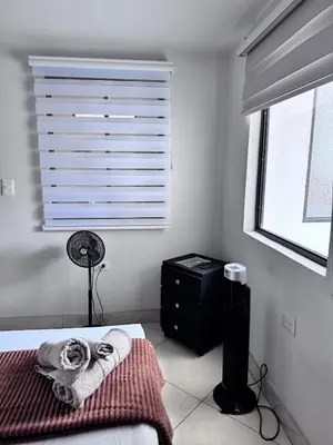 a bedroom with a bed and a window with blinds at Acogedor Apartamento en la ciudad de Medellín- La floresta in Medellín