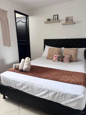 a bed with two pillows on it in a bedroom at Acogedor Apartamento en la ciudad de Medellín- La floresta in Medellín