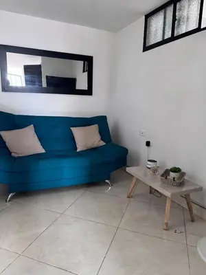 a blue couch in a living room with a table at Acogedor Apartamento en la ciudad de Medellín- La floresta in Medellín