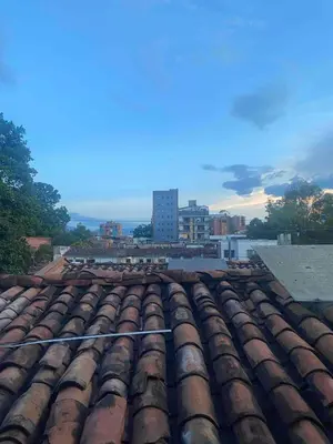 a group of roofs with a city in the background at Acogedor Apartamento en la ciudad de Medellín- La floresta in Medellín