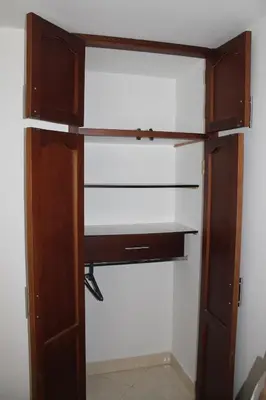 a closet with a wooden door and shelves at Acogedor Apartamento en la ciudad de Medellín- La floresta in Medellín
