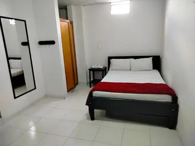 a bedroom with a bed with a red blanket and a mirror at Hotel Galerias in Ruiosucio