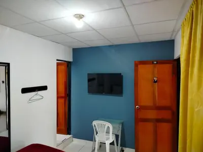 a room with a blue wall and a table and a chair at Hotel Galerias in Ruiosucio