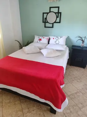 a large bed with a red blanket on it at Encantadora finca en el corazón de Marinilla con vistas únicas y ubicación privilegiada in Marinilla