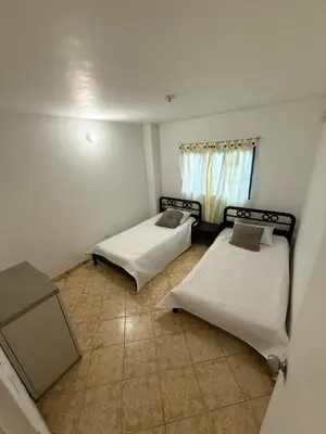two beds in a small room with a window at Encantadora finca en el corazón de Marinilla con vistas únicas y ubicación privilegiada in Marinilla
