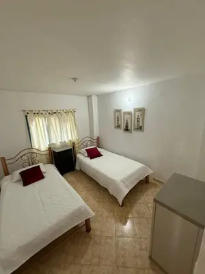 a room with two beds and a counter in it at Encantadora finca en el corazón de Marinilla con vistas únicas y ubicación privilegiada in Marinilla