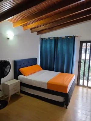 a bedroom with a bed with blue curtains at Apartamento completo cerca del estadio in Medellín