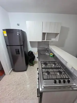 a kitchen with a stove and a refrigerator at Apartamento completo cerca del estadio in Medellín