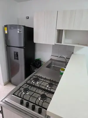 a kitchen with a stove and a stainless steel refrigerator at Apartamento completo cerca del estadio in Medellín