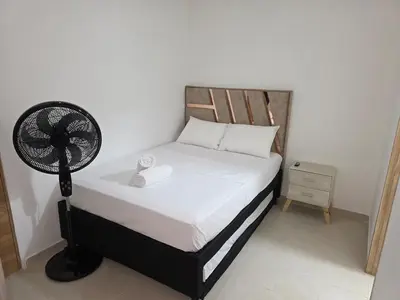 a bedroom with a bed with a fan on it at Apartamento completo cerca del estadio in Medellín