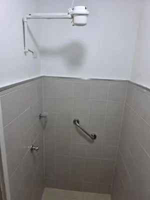 a tiled shower with a hand rail in a bathroom at Apartamento completo cerca del estadio in Medellín