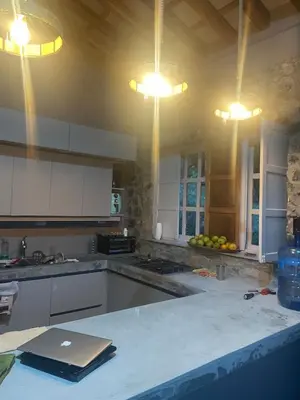a kitchen with white cabinets and a laptop on a counter at Casa de Campo Cerca a Medellín in Angelópolis