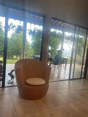a person sitting at a table in a room with a chair at Casa de Campo Cerca a Medellín in Angelópolis