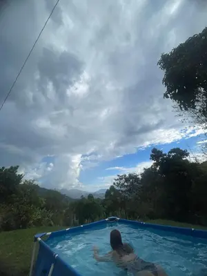 a woman in a swimming pool with a view at Casa de Campo Cerca a Medellín in Angelópolis