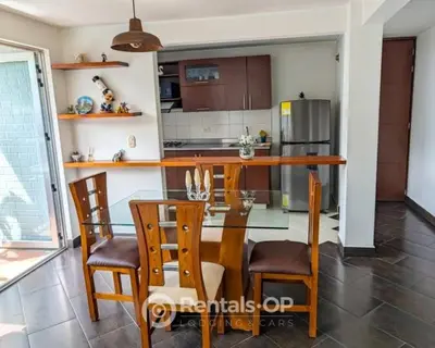 a kitchen with a glass table and wooden chairs at Spacious apartment near Lleras and Provenza rentalsOP AN08 in Medellín